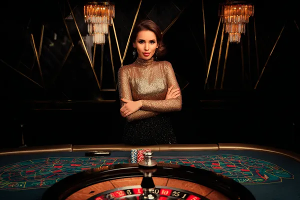 BINGOMAX Slots — Thousands of thrilling machines await A woman smiling by bright slot machines showing lucky symbols, showcasing the exciting slot offerings at BINGOMAX.